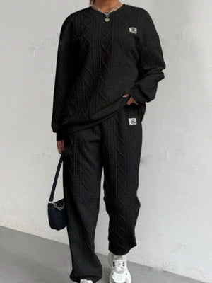 Black cable knit loungewear set with crew neck sweater and wide leg pants.