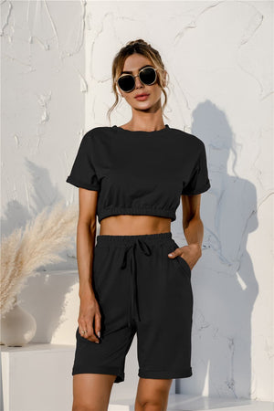 Black loungewear set with rolled sleeve crop top and drawstring shorts