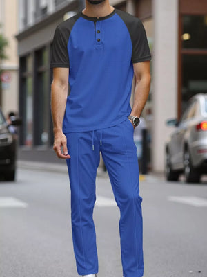 Men's blue loungewear set with black raglan sleeves and drawstring pants.