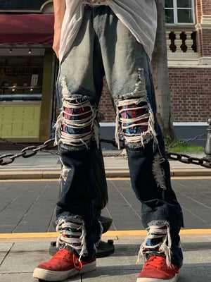Loose fit distressed jeans with two-tone denim and patterned patches.