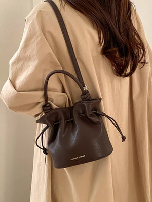 Brown pu leather cinch-top crossbody bag with drawstring and knotted strap detail