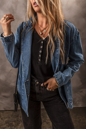 Medium wash denim double-breasted blazer with a notched lapel and button front.