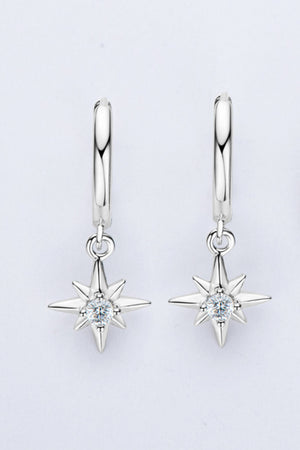 Silver hoop earrings with dangling starburst charms featuring a central crystal.