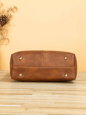 Geometric strap crossbody bag in tan PU leather with gold stud feet.