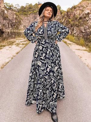 Dark navy paisley print tiered maxi dress with V-neck and long sleeves.