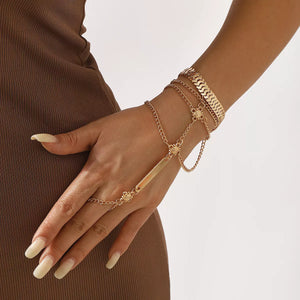 Gold multi-layered chain bracelet with flower accents and a bar detail.