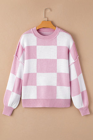 Checkerboard knit crewneck sweater in dusty pink and white with balloon sleeves.