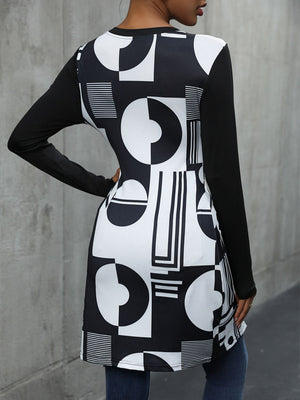 Black tunic top with asymmetric geometric print and long sleeves.