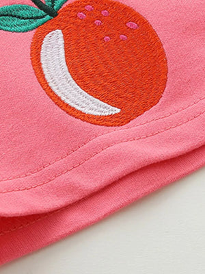 Pink cotton baby shorts with embroidered orange fruit detail.