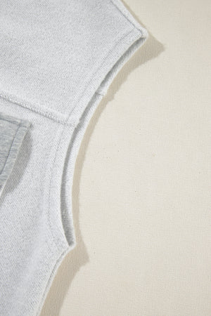 Light gray cotton utility vest detail showing contrast trim and stitching.