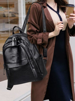 Black pu leather medium backpack with multiple compartments and zippered pockets.