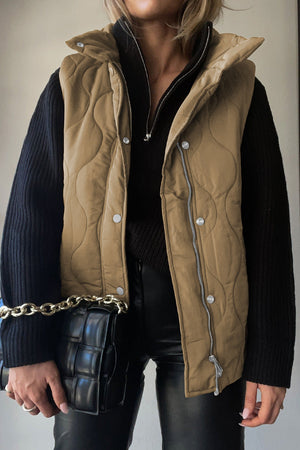 Quilted stand-collar utility gilet in taupe with diamond stitching and silver hardware.