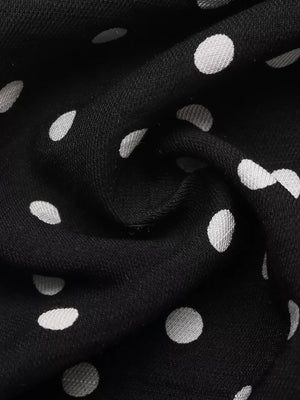 Black polka dot dress fabric with a ruffled hem detail