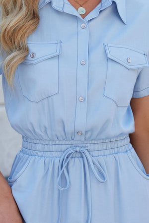 Light blue shirtdress with drawstring waist, collared, short sleeves, and chest pockets.