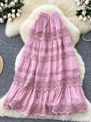 Pink tiered maxi skirt with lace trim and drawstring waist.
