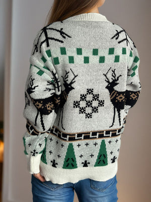 White knit sweater with reindeer, snowflake, and Christmas tree motifs.