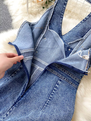 Light blue denim jumpsuit with halter neck and wide legs, showing zipper detail.
