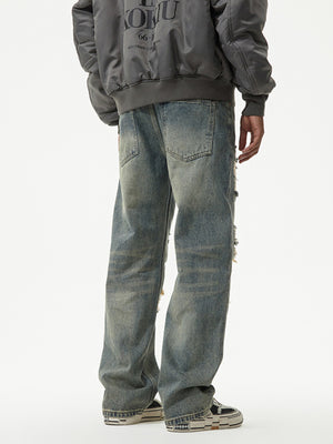 Distressed blue denim wide leg jeans with ripped details.