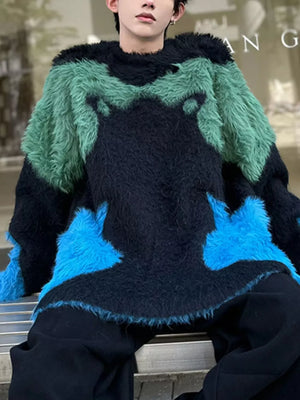 Oversized knit sweater with black, green, and blue color block fuzzy panels and raw hem.