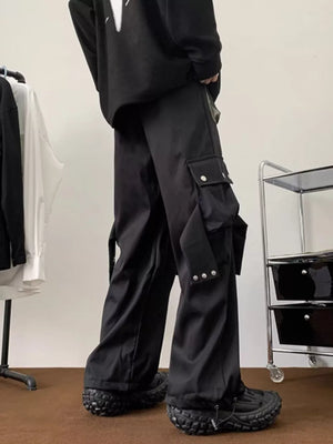 Men's black relaxed-fit cargo pants with multiple pockets and strap details.