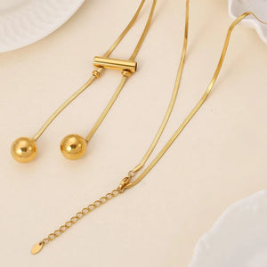 Gold lariat necklace with sphere drops and adjustable chain, 18K gold-plated.