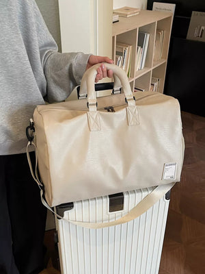 Off-white pu leather duffel bag with top handles and shoulder strap, spacious travel tote.
