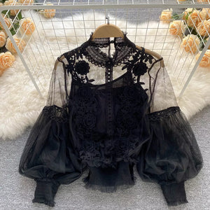 Black sheer lace blouse with floral embroidery and puff sleeves.
