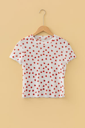 White sheer t-shirt with red heart print, short sleeves, and lettuce hem.