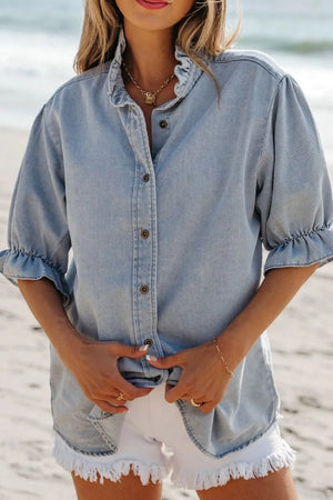Light blue denim blouse with ruffled collar and puff sleeves, button front.