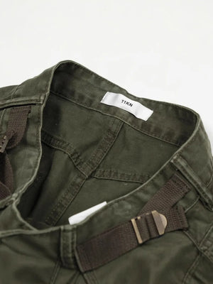 Dark green cargo pants with adjustable belt detail and multi-pocket design.