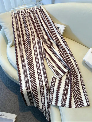 Maternity wide-leg pants in white with a brown geometric chevron print and bow detail.
