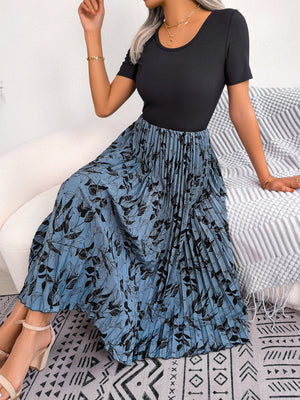Botanical pleated midi dress in dark blue with black floral print, featuring a black ribbed top and A-line skirt.