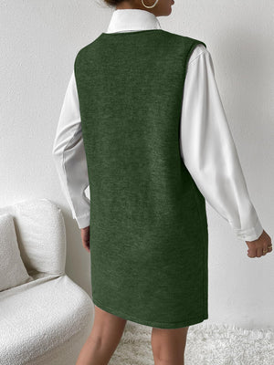 Dark green knit sleeveless mini dress with pocket detail, worn over a white shirt.