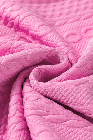 Pink textured knit loungewear fabric with cable knit pattern detail