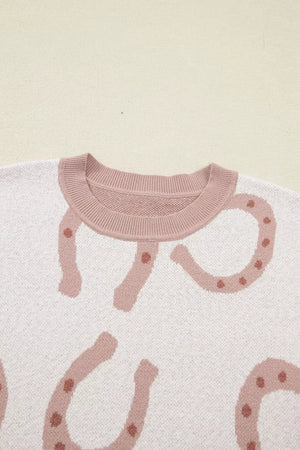 White knit top with pink horseshoe pattern and crew neck.