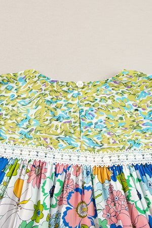 Floral patchwork blouse with puff sleeves, featuring a white button back and lace trim.
