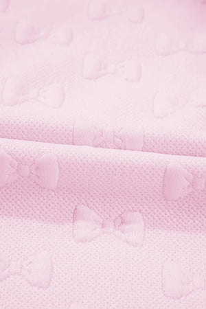Blush pink loungewear set with embossed bow pattern and ruffle sleeves.