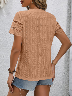 Camel eyelet blouse with scalloped short sleeves and intricate all-over pattern.