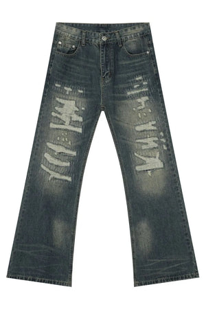 Distressed flare jeans in medium wash denim with graffiti-style rips and patches.