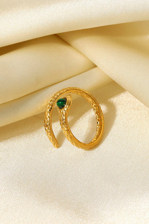 Gold serpentine ring with malachite eye detail and textured coil design.