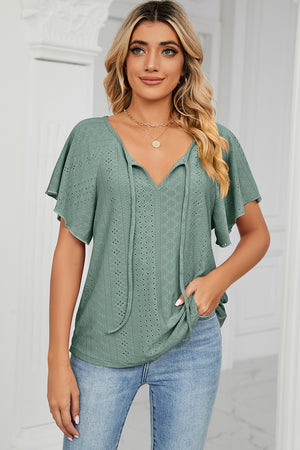 Light green eyelet tie-neck blouse with flutter sleeves and V-neck.