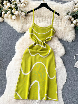 Green wavy knit midi dress with spaghetti straps and white abstract pattern.