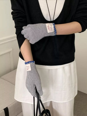 Gray ribbed knit gloves with blue trim and a white tag detail.