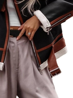 Black shearling lined zip up jacket with brown trim and white sherpa cuffs.