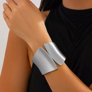 Sculptural silver-toned cuff bracelet with a modern, open design.