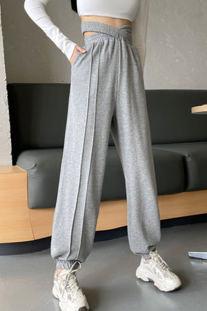 Gray Dawn pleated waistline joggers with elastic cuffs and front seam detail.