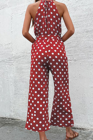 Red polka dot halter neck palazzo jumpsuit with belted waist.