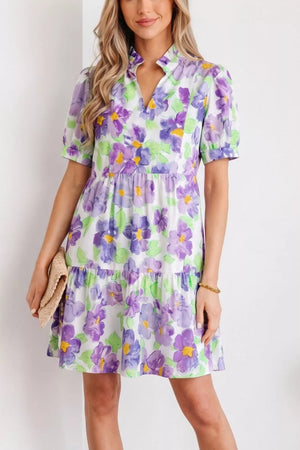 Vibrant floral tiered ruffle mini dress with short sleeves and a mock neck.