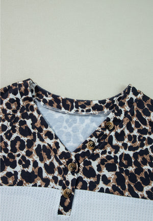 Leopard print henley sweater with button detail and waffle knit bottom in white.