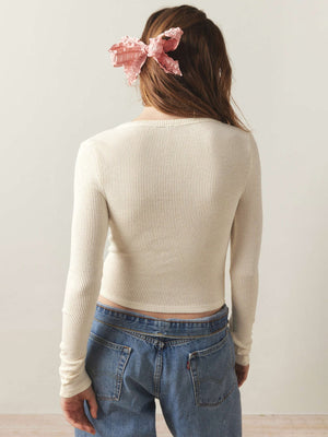 Cream ribbed long sleeve crop top with a crew neck, styled with jeans.